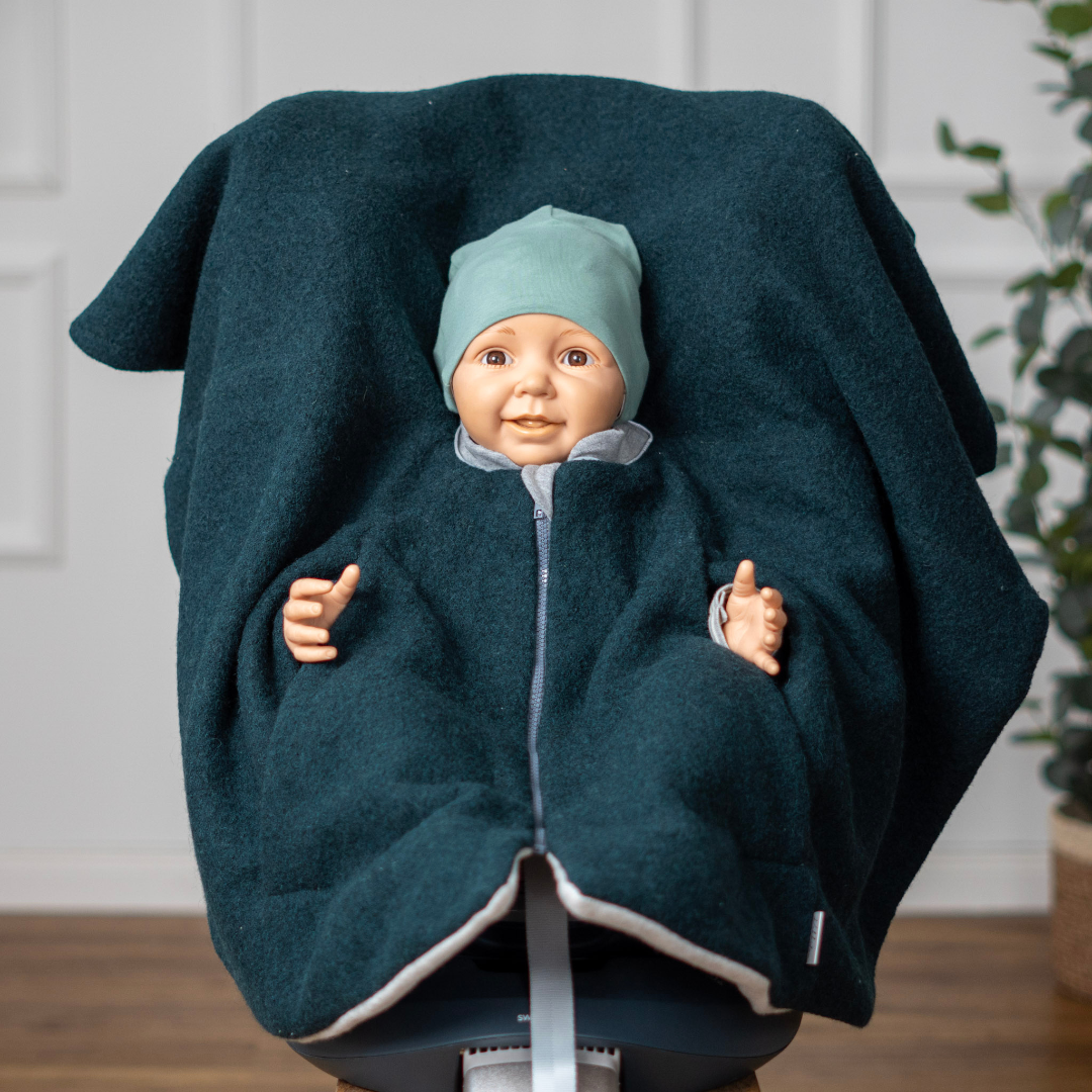 Kind im Kindersitzponcho Wollwalk – sicher anschnallen ohne dicke Jacke - Grün