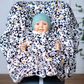 Kind im Kindersitz-Poncho aus Fleece – sicher & warm unterwegs - weiß mit Leo Muster 