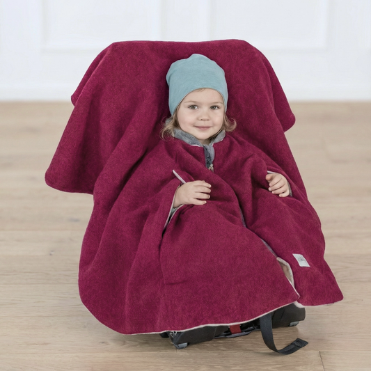 Kind im Kindersitzponcho Wollwalk – sicherer anschnallen ohne dicke Jacke - dunkles Pink