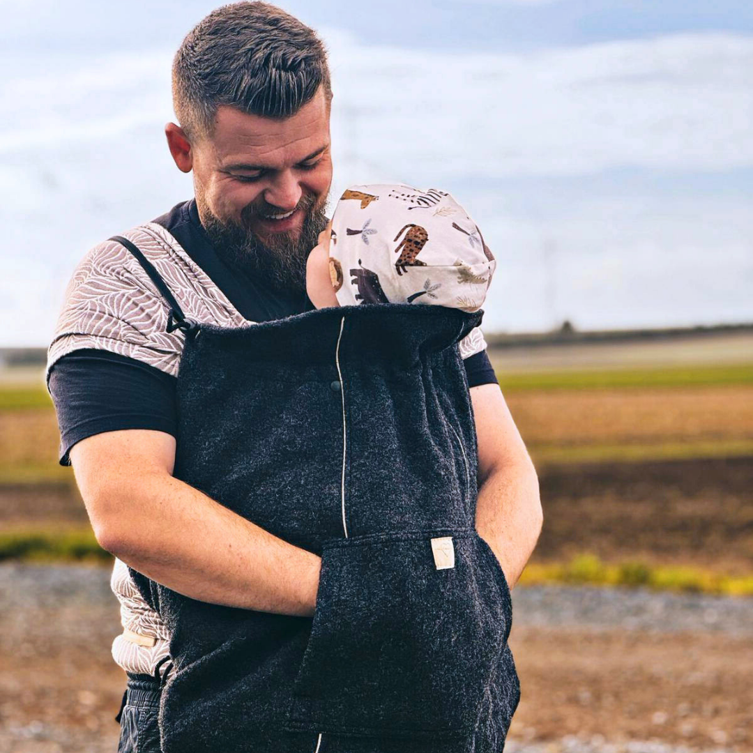 Baby im Tragetuch mit Tragecover aus Wollwalk in Anthrazit – natürlicher Wetterschutz für Herbst und Winter, flexibel einsetzbar bei jedem Tragesystem
