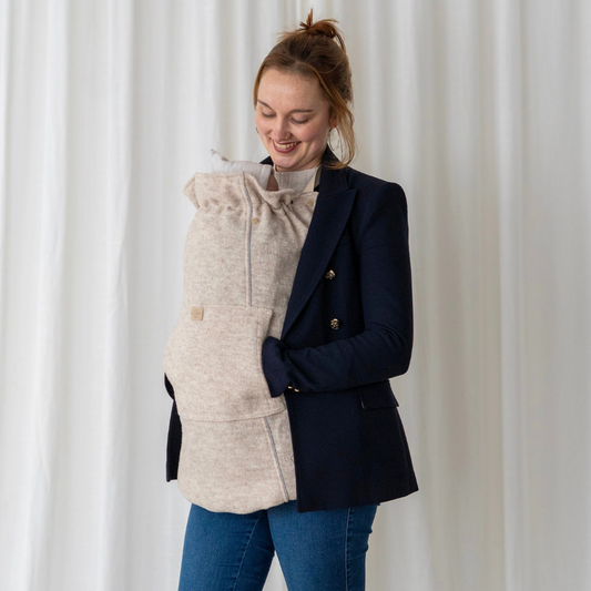 Baby im Tragetuch mit Tragecover aus Wollwalk in Beige – natürlicher Wetterschutz für Herbst und Winter, flexibel einsetzbar bei jedem Tragesystem